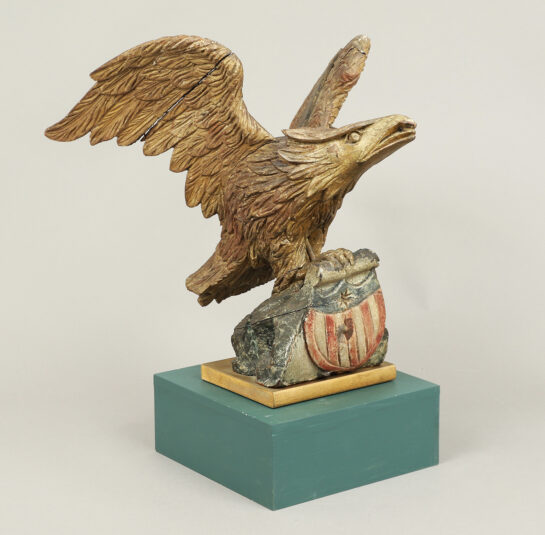 Carved Eagle with Swept-Back Wings Perched on a Rock with Shield